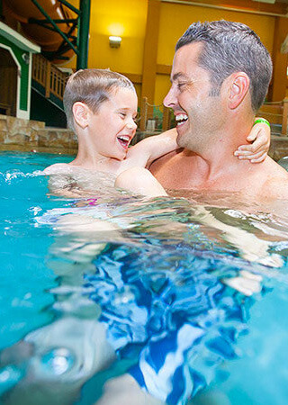 Father and Son swimming in pool.