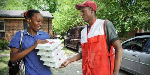 Woman receiving food aid from relief worker.