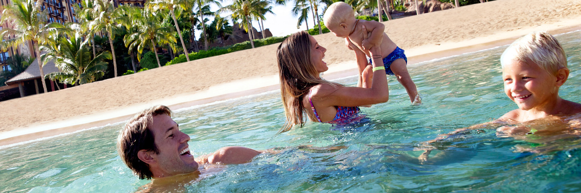 Family in clear ocean water having fun.