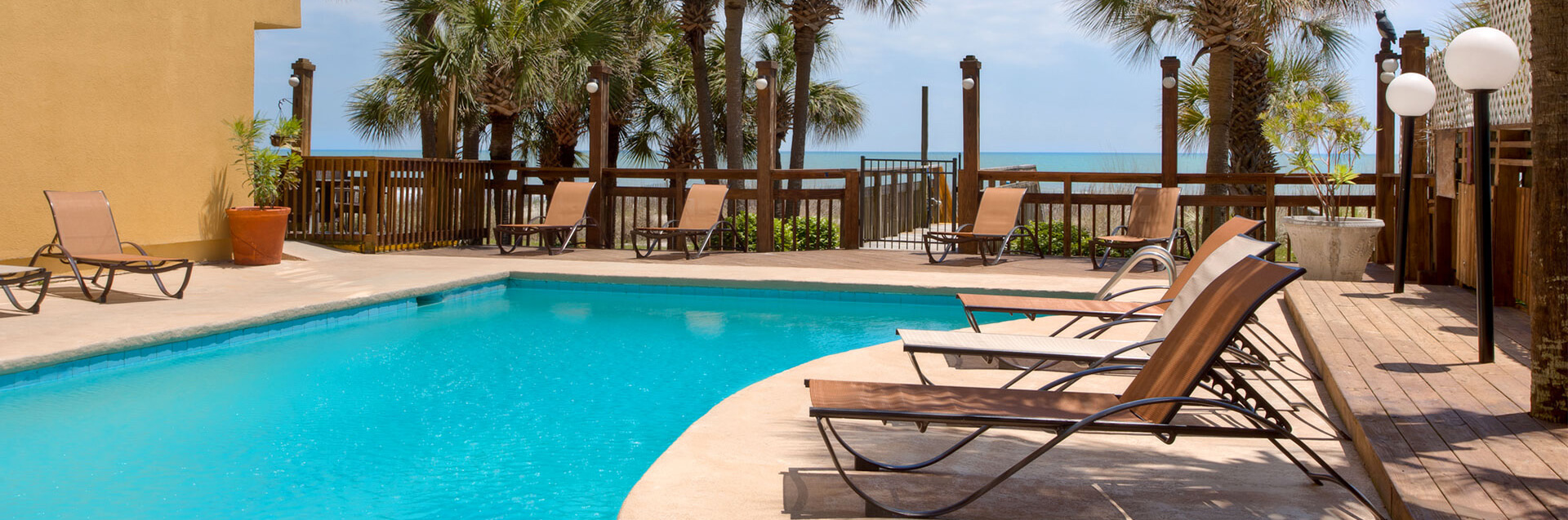 Beautiful vista overlooking the ocean from deck with a pool.