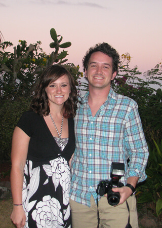 Couple having their photo taken outside at dusk.